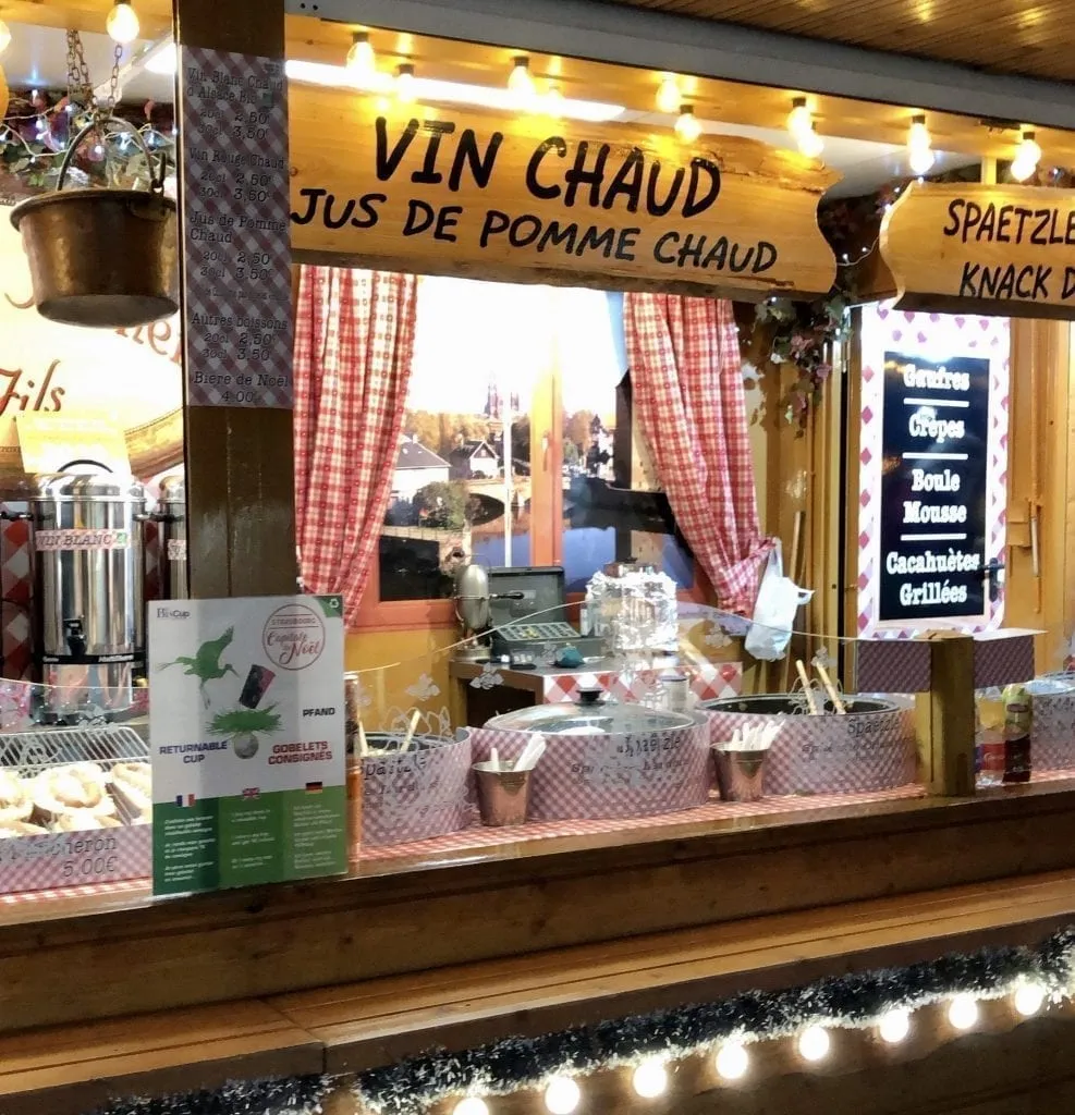 Christmas market stall in Strasbourg selling Vin Chaud with a menu on the right side