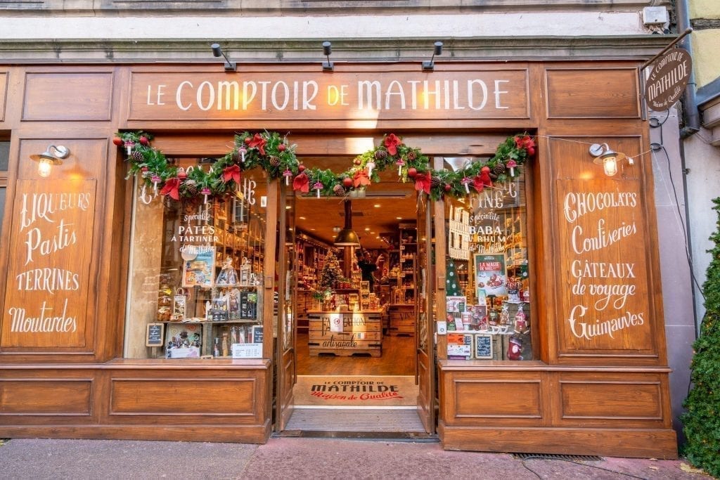 Photo of wooden Le Comptoir de Mathilde storefront in Colmar France, decorated for Christmas