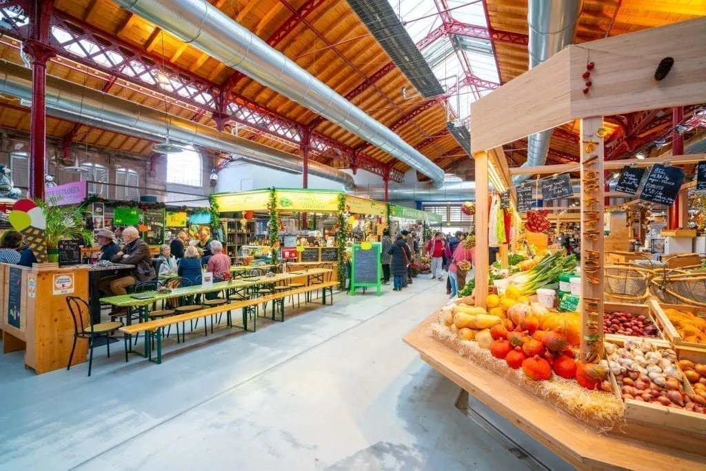 Interior of the Covered Market with fruit and vegetable stands showing. Visiting the covered market is one of the best things to do in Colmar France