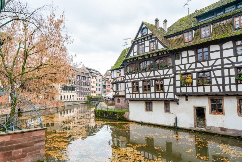 La Petite France neighborhood in Strasbourg France with a half-timbered house on the right and a canal on the left