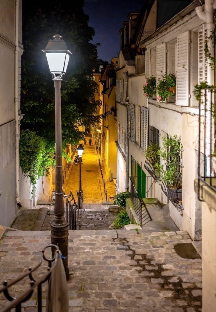 street in Montmartre in Paris at night with a streetlight to the left. Montmartre is a great neighborhood to spend an evening in Paris