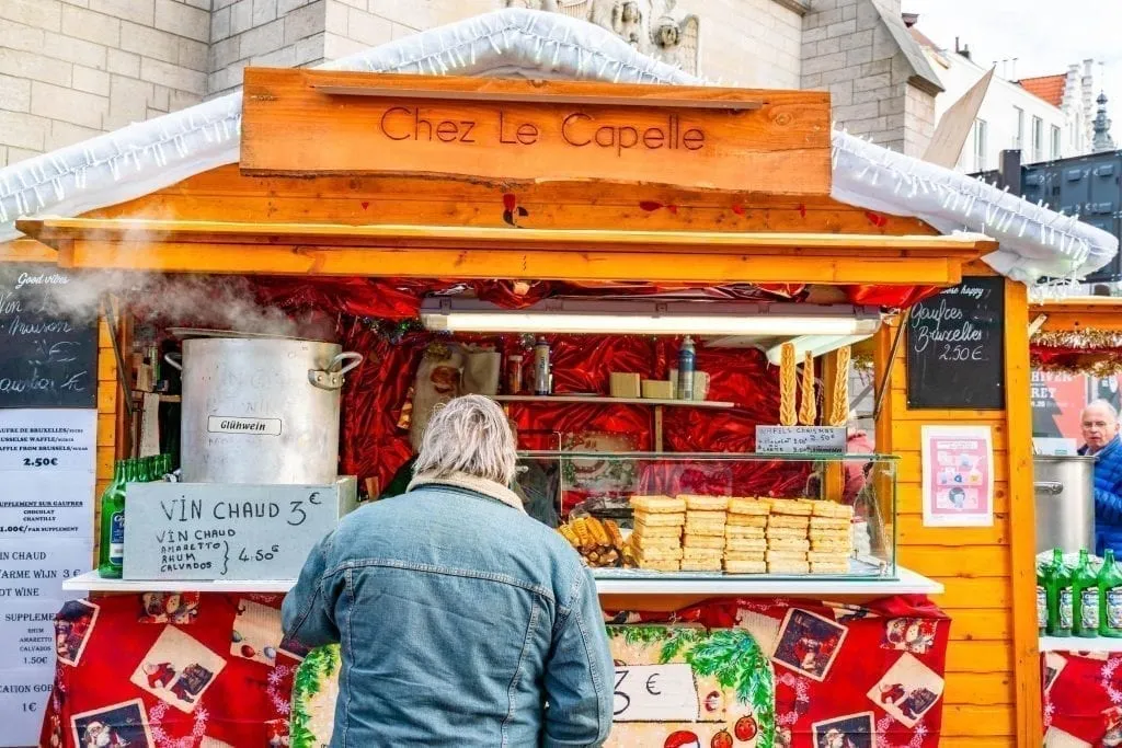 man buying gluhwein at belgium christmas market
