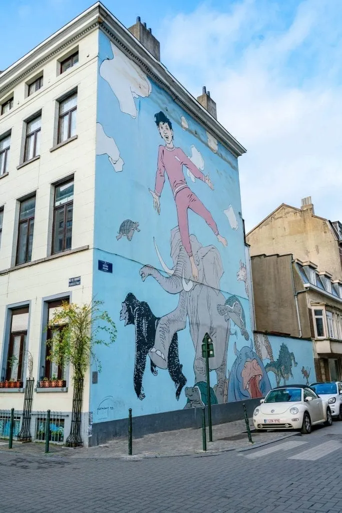 Blue mural with a boy in pink pajamas painted on it along the Comic Book Route in Brussels