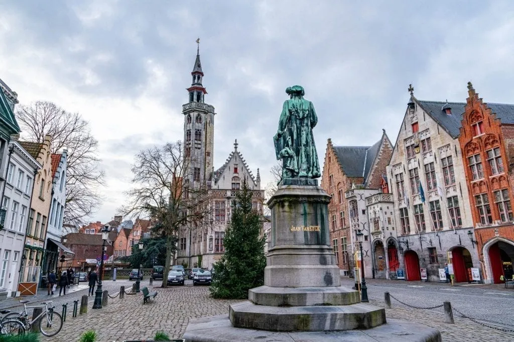 statue in the center of a square in brugge belgium on a moody winter day