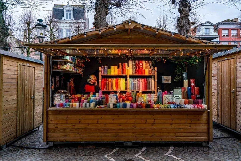 christmas market souvenirs for sale in wood chalet, stand selling candles