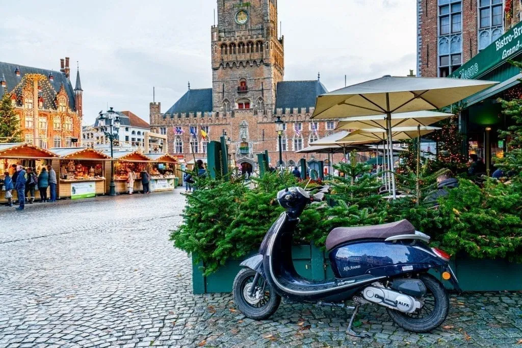 Grote Markt in Bruges with a parked vespa in the foreground