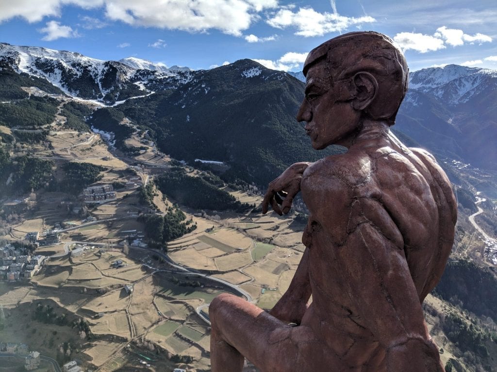 Bronze statue of a man overlooking a vista with mountains in the background on one of the shortest, prettiest road trips in Europe: from Barcelona to Andorra