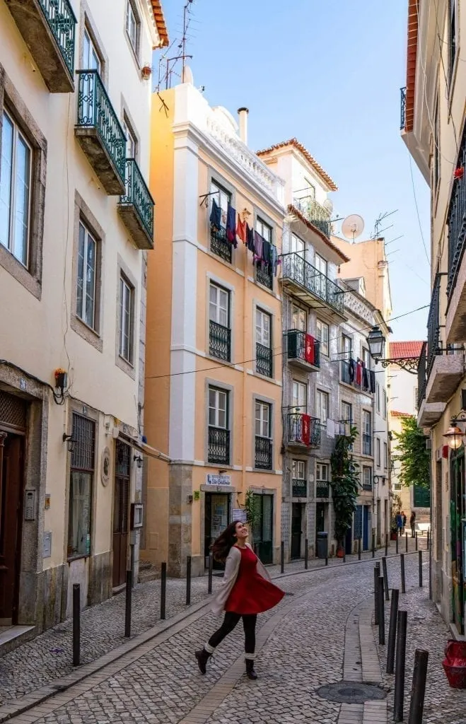 Kate Storm in Lisbon Portugal on a sunny day with tiled buildings behind her