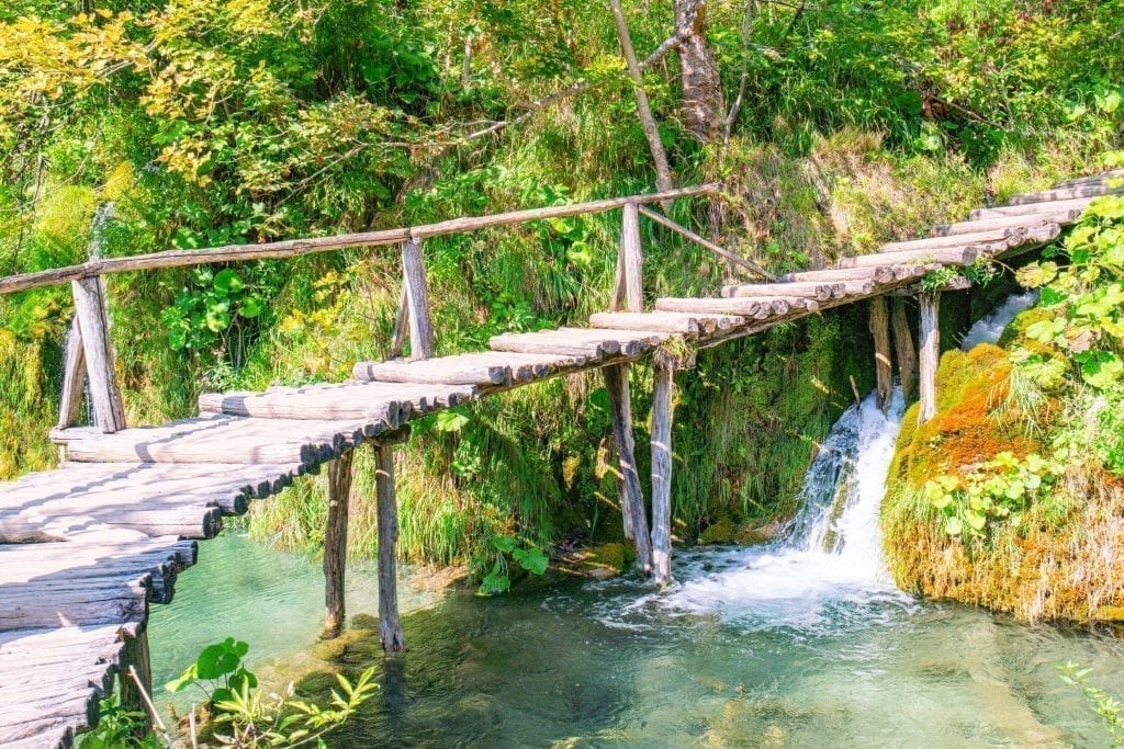 Boardwalk as seen on a Plitivce Lakes vacation, photographed from the side showing how it is elevated above a small waterfall