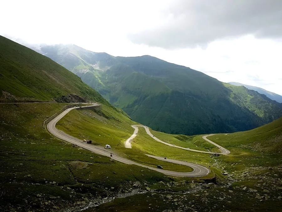 Transfăgărășan road winding through the mountains of Romania on a cloudy day--definitely not the easiest road trip in Europe as far as driving goes!