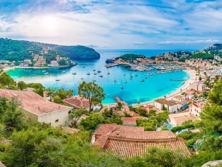 Soller Mallorca from above, with sailboats parked in the brightly covered bay. Mallorca is one of the best road trips in Europe!