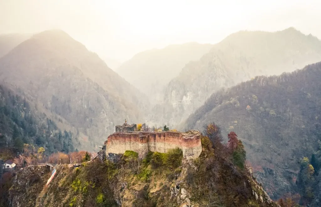 aerial view of Poenari Castle romania with mountains in the background at golden hour