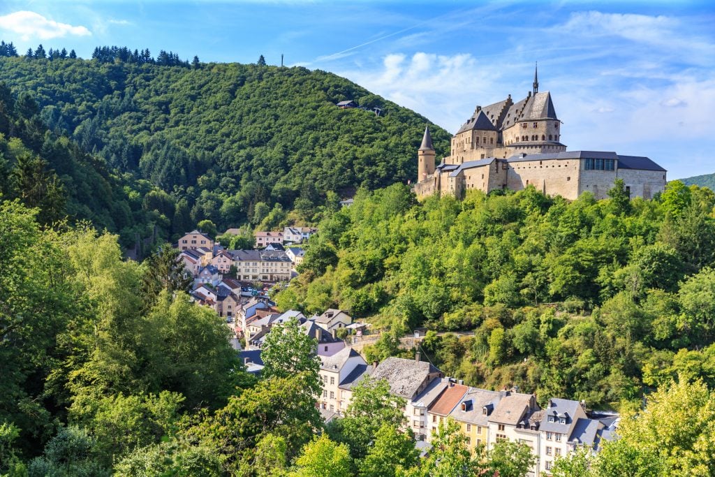 vianden castle from a distance overlooking the village in the mountains of luxembourg