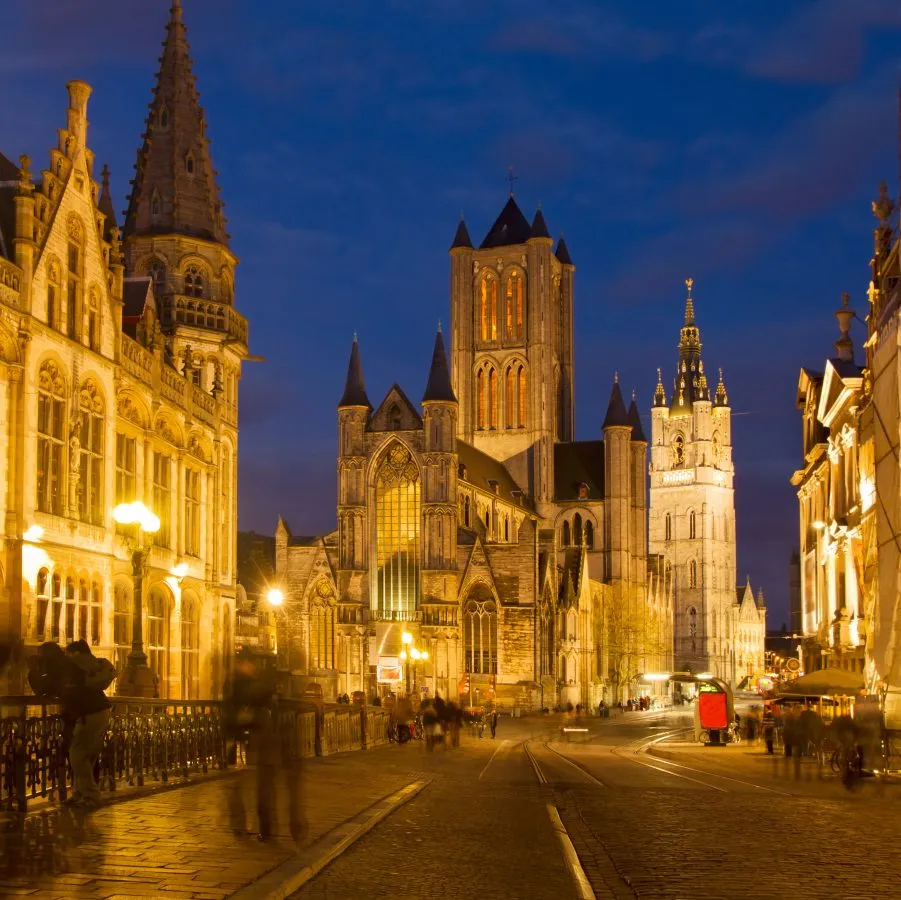 st nicholas church with belfry behind it at night in ghent during blue hour