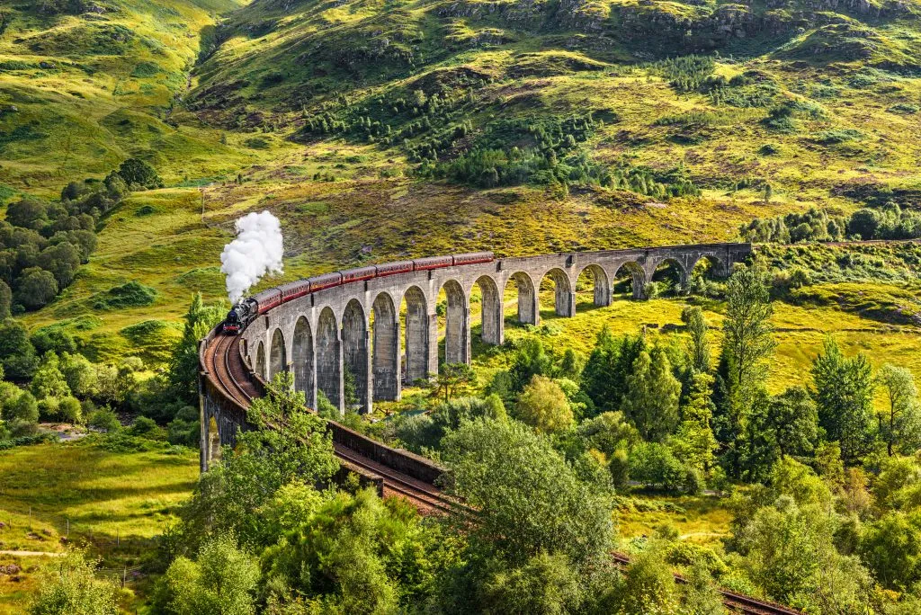 jacobite steam train crossing viaduct in the scottish highlands