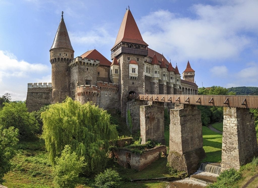 Corvin Castle in Transylvania with a bridge to the right side. Transylvania is one of the best road trips in Europe