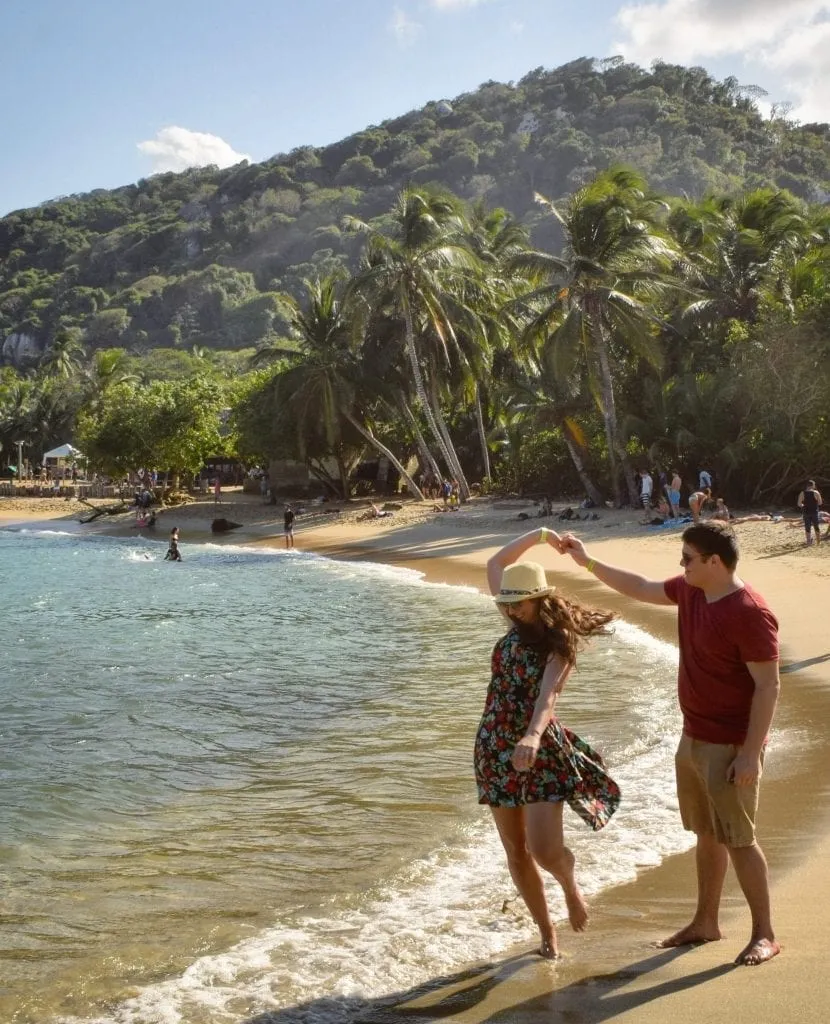 Kate Storm and Jeremy Storm spinning together on a beach in Tayrona National Park Colombia. Be sure to bring sunglasses and a dress