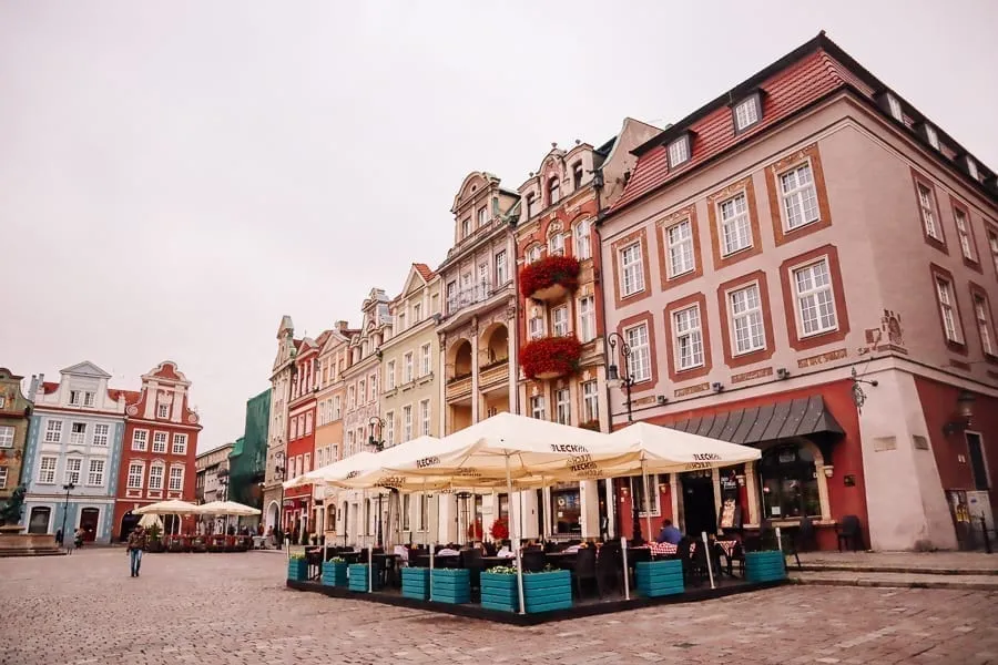 Colorful street in Poznan Poland with cafe visible in the foreground. Poznan is a great destination for those looking to explore Europe off the beaten path