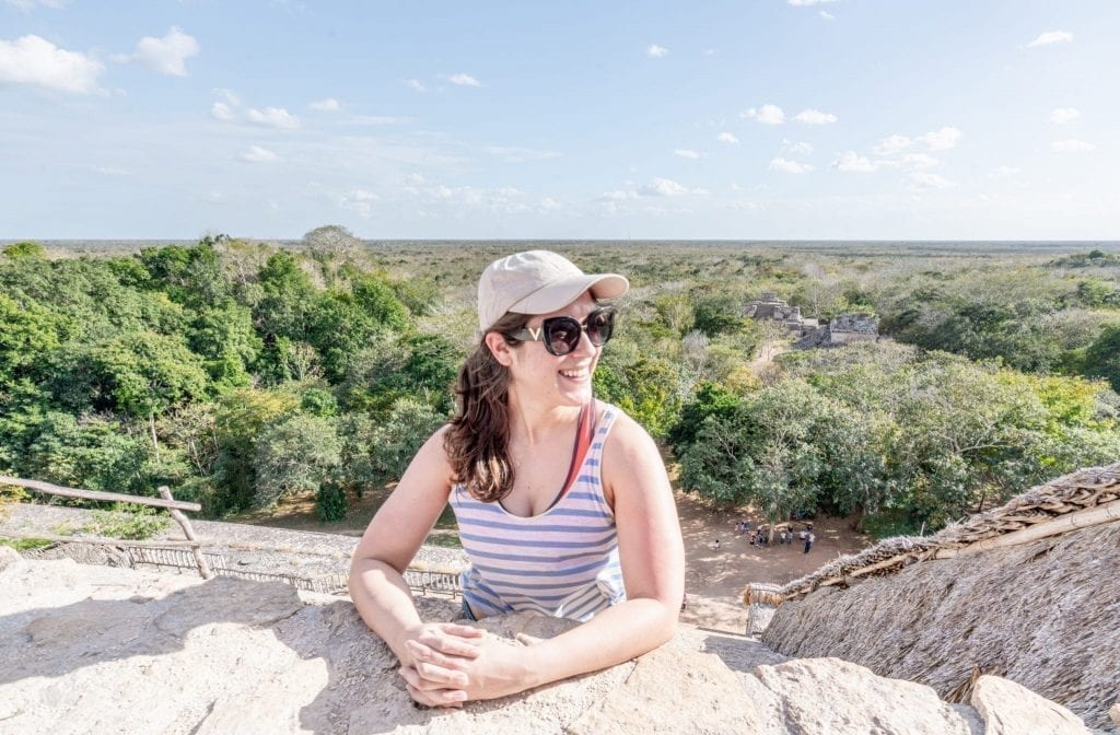 Kate Storm standing on top of the el torre pyramid in ek balam with jungle visible behind her