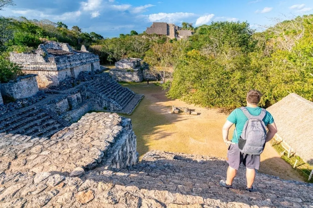 Jeremy Storm in Ek Balam facing away from the camera, standing on top of one ruin and overlooking the others