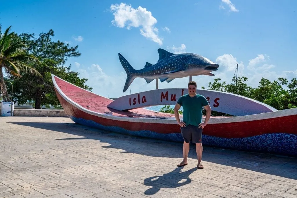 Jeremy Storm standing in front of Isla Mujeres sign with a whale shark on top of it
