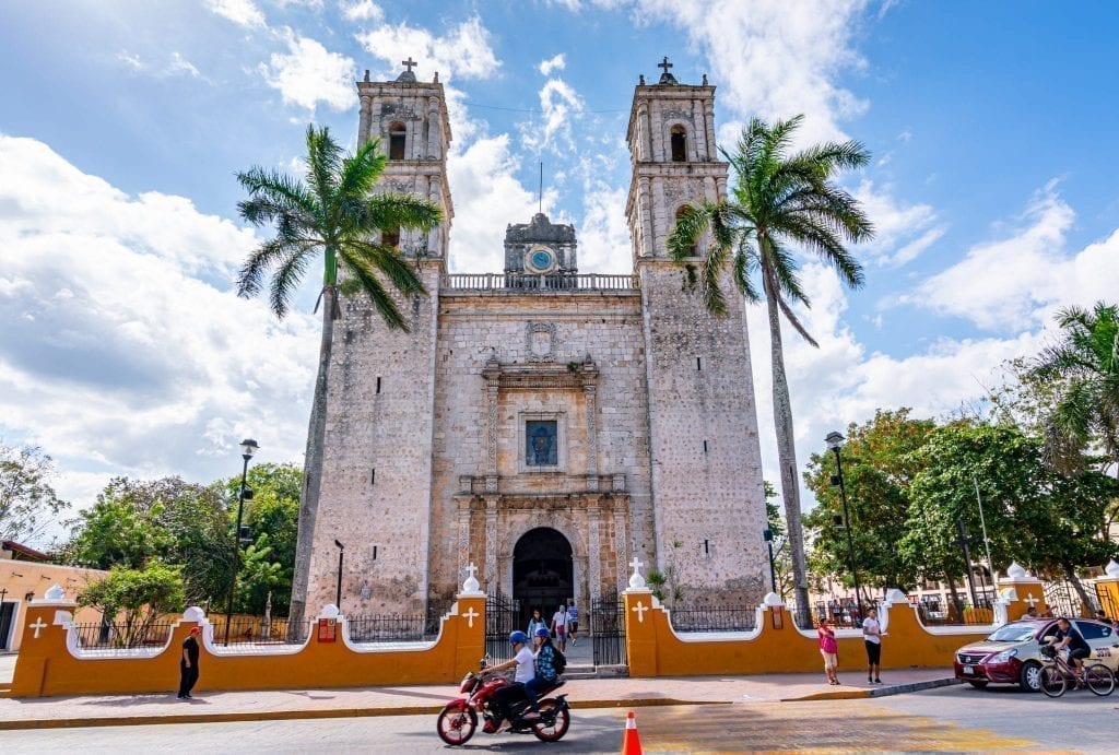 Valladolid Cathedral with a motorbike passing by in front of it. Valladolid is an excellent base during this first part of this Mexico road trip itinerary