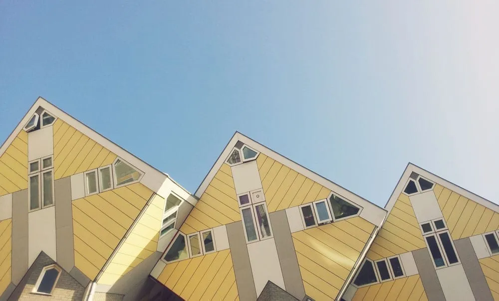 Yellow cube houses of Rotterdam with blue sky above them. Rotterdam is an excellent European hidden gem to visit