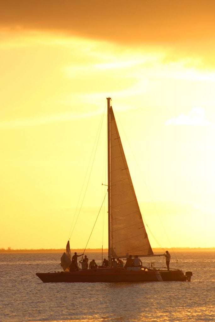 catamaran sailing on the water at sunset, one of the best activities isla mujeres mexico