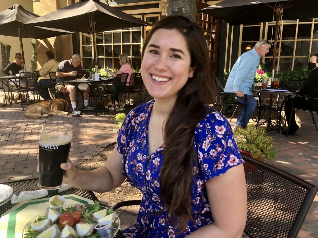 kate storm holding a guinness while eating at the six pence pub savannah georgia