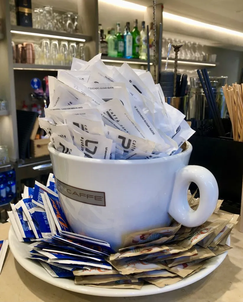 large cup of sugar packets in italy coffee bar
