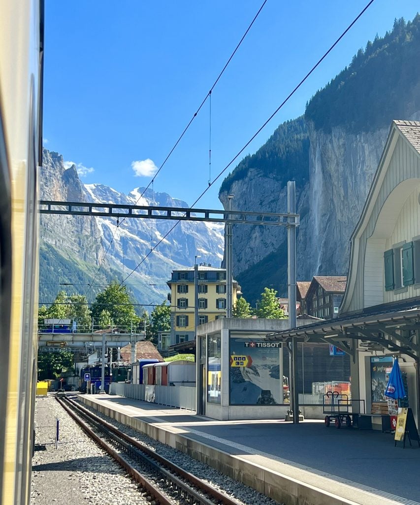 ga xe lửa ở lauterbrunnen Thụy Sĩ nhìn từ một chuyến tàu với thác nước ở phía sau