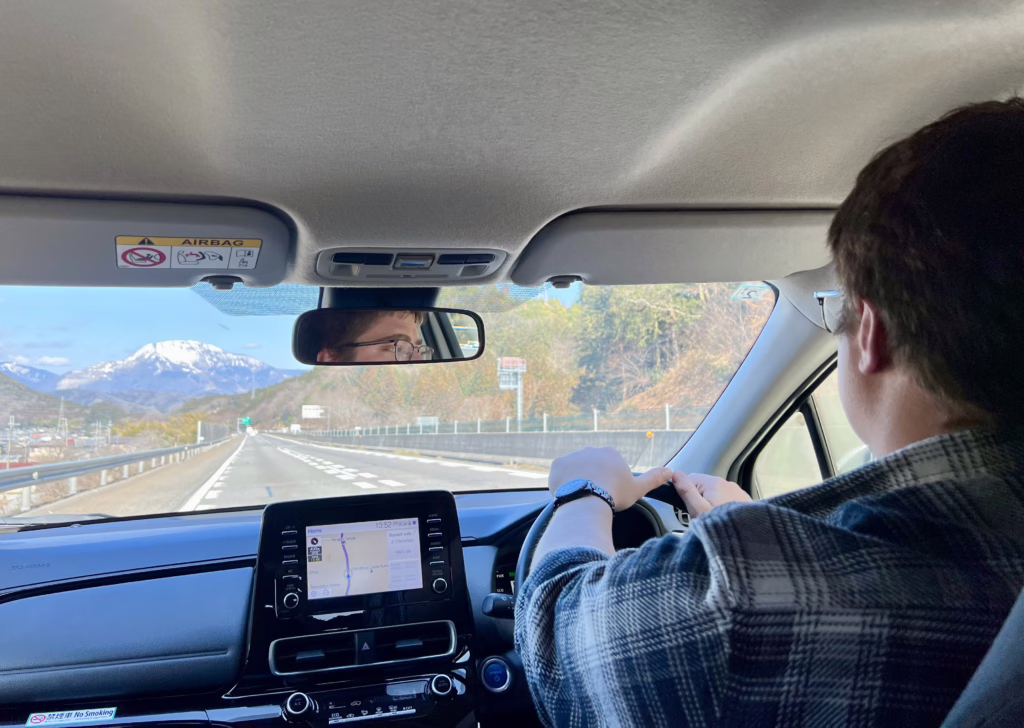 view of a snowy mountain through a car windshield when driving in japan
