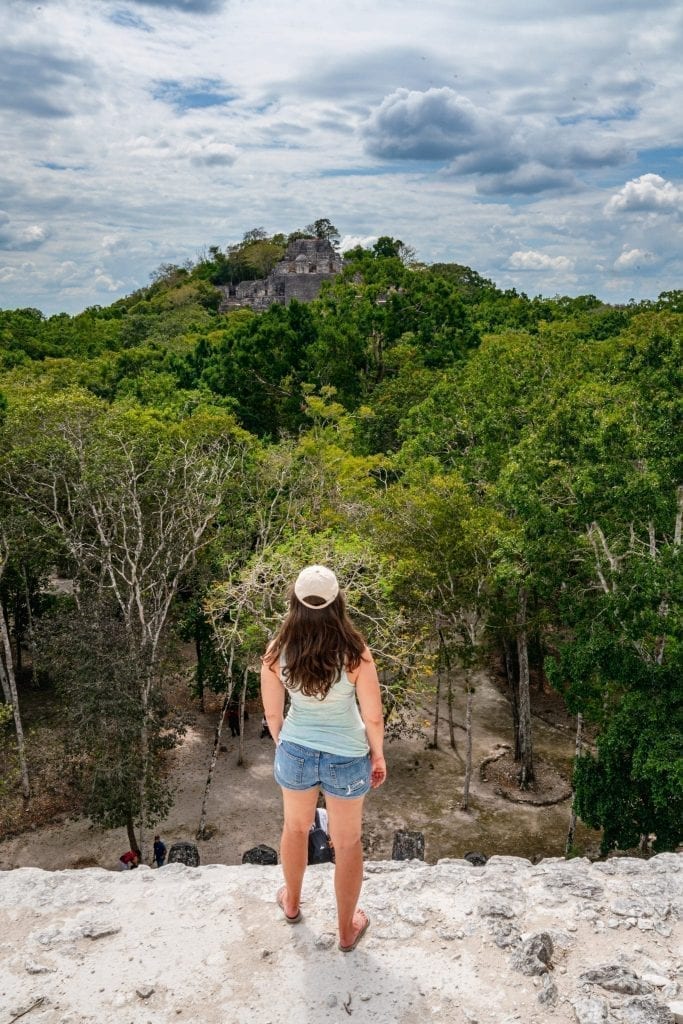 kate storm standing on top of a pyramid in calakmul, one of the best mayan ruins mexico