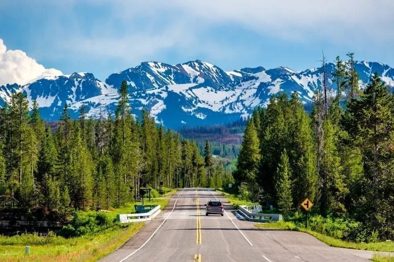 Road to Grand Tetons from Yellowstone with mountains visible in the distance, one of the best road trips in USA