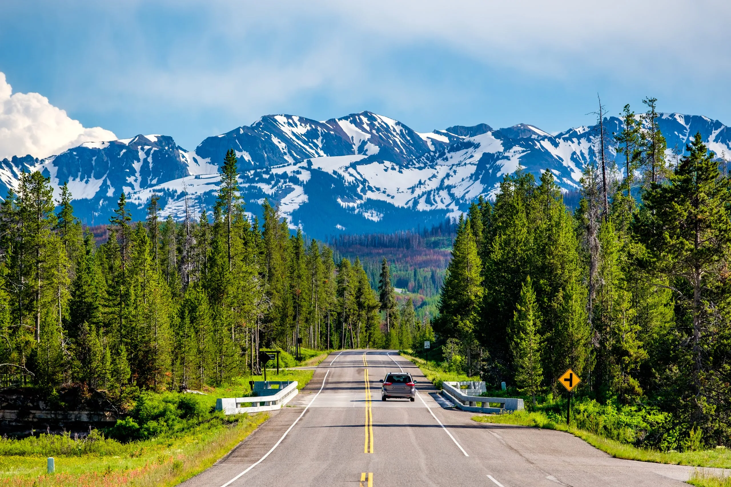 Road to Grand Tetons from Yellowstone with mountains visible in the distance, one of the best road trips in USA