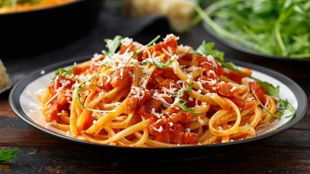 Plate of Amatriciana on a black plate. Amatriciana is a traditional food in Rome Italy