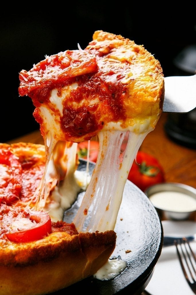 Deep Dish Pizza in Chicago being sliced and served, one of the most important foods to eat during your 3 day Chicago itinerary!