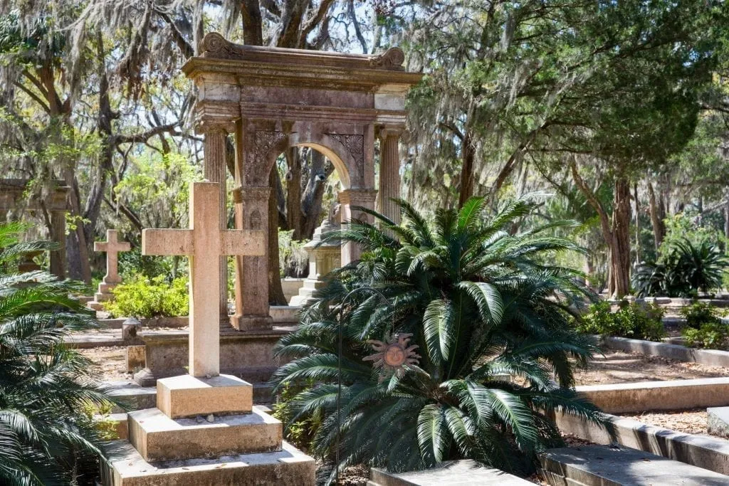 Bonaventure Cemetery in Savannah GA with a cross visible on the left and a larger statue behind it