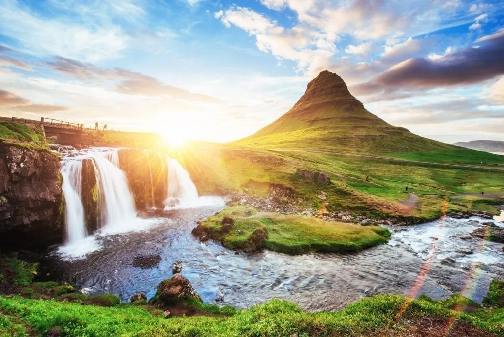 Sunset over waterfalls in Iceland, one of the best places to visit in Europe in summer