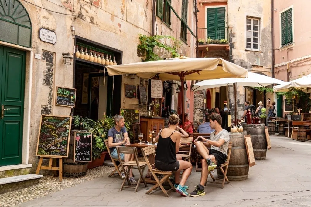 tourists sitting at a restaurant in cinque terre servizio italy explained