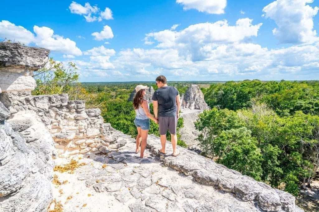 Kate and Jeremy Storm standing on the edge of a Mayan pyramid in Becan Mexico, facing each other