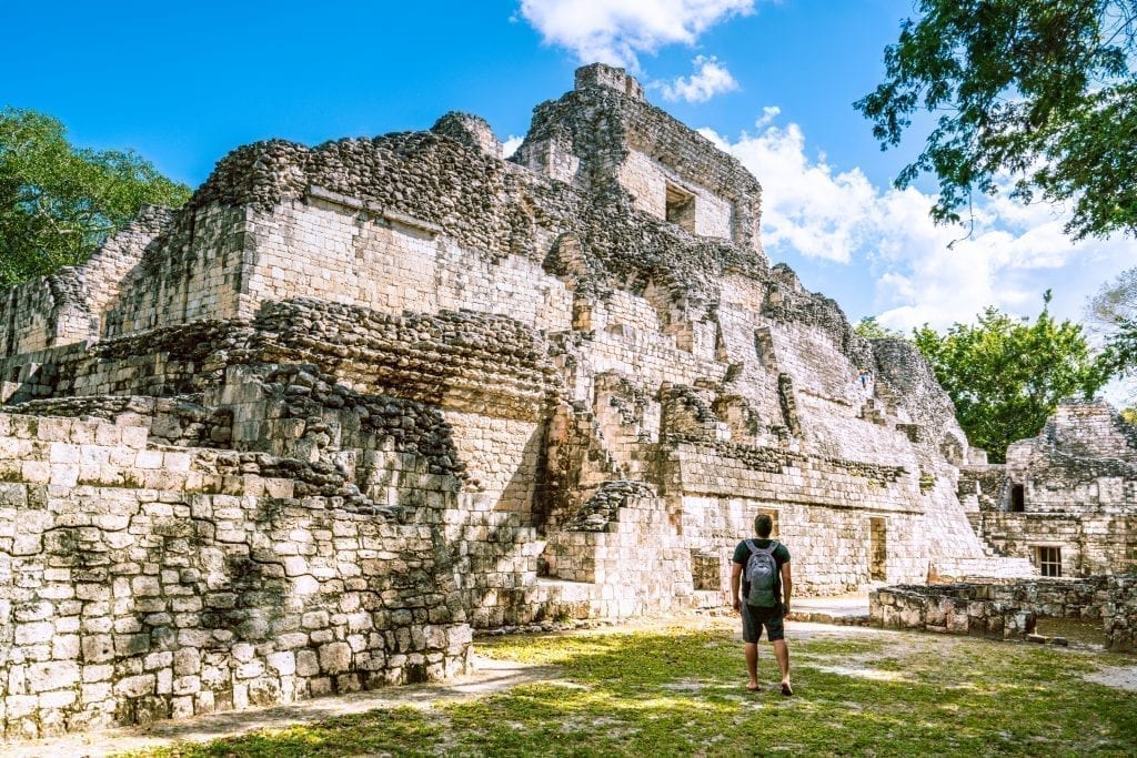 Jeremy Storm standing in front of a large Mayan structure in Becan Mexico, looking away from the camera