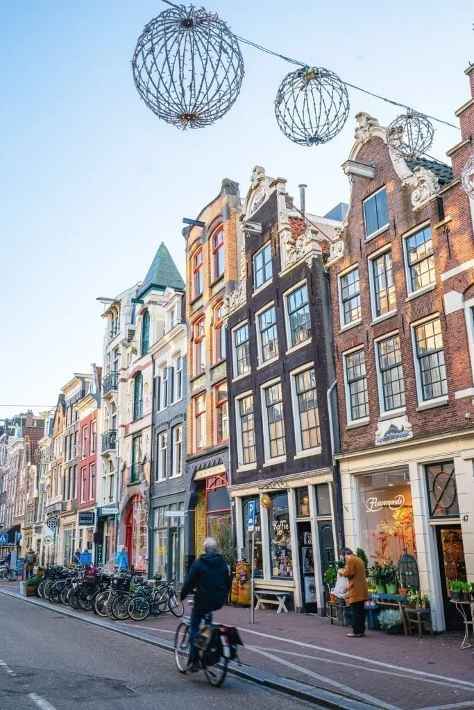 person riding a bike down the street in amsterdam netherlands