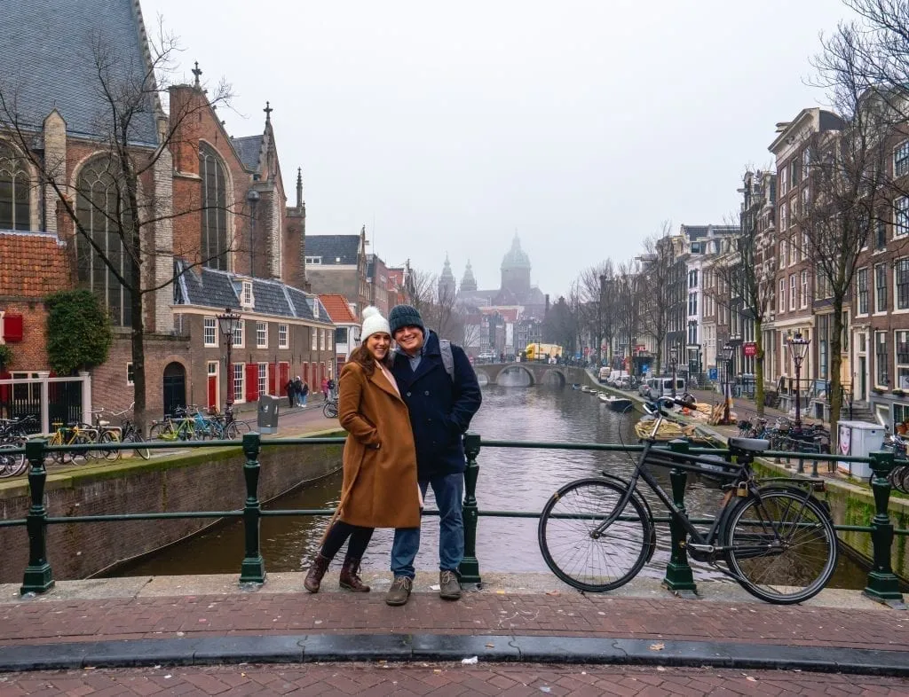 Jeremy Storm and Kate Storm standing on a bridge over a canal during December in Amsterdam
