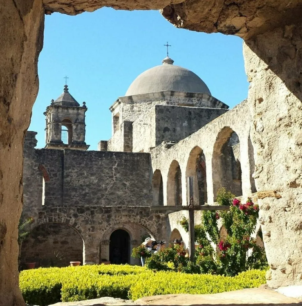 San Jose Mission in San Antonio Texas as seen through a stone window. San Antonio is one of the best places to visit in Texas.