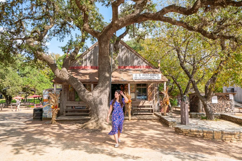 kate storm in a blue dress in front of the luckenbach post office