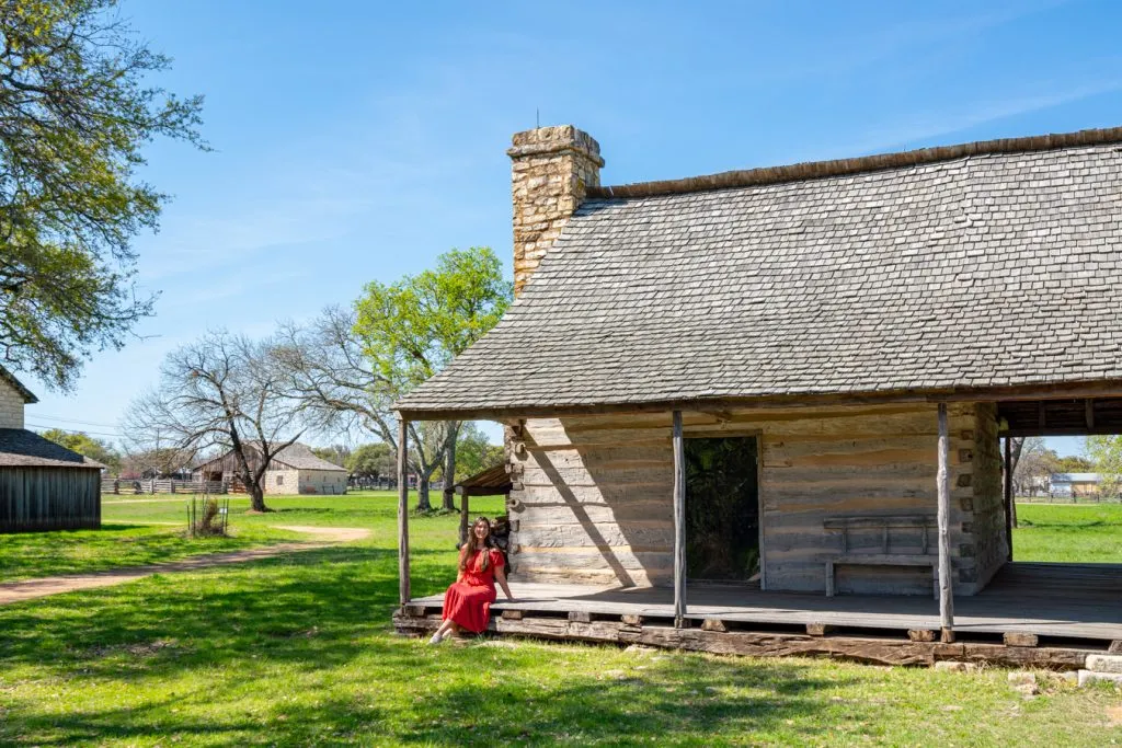 kate storm in a red dress in front of a historic building in johnson city, one of the best weekend getaways texas