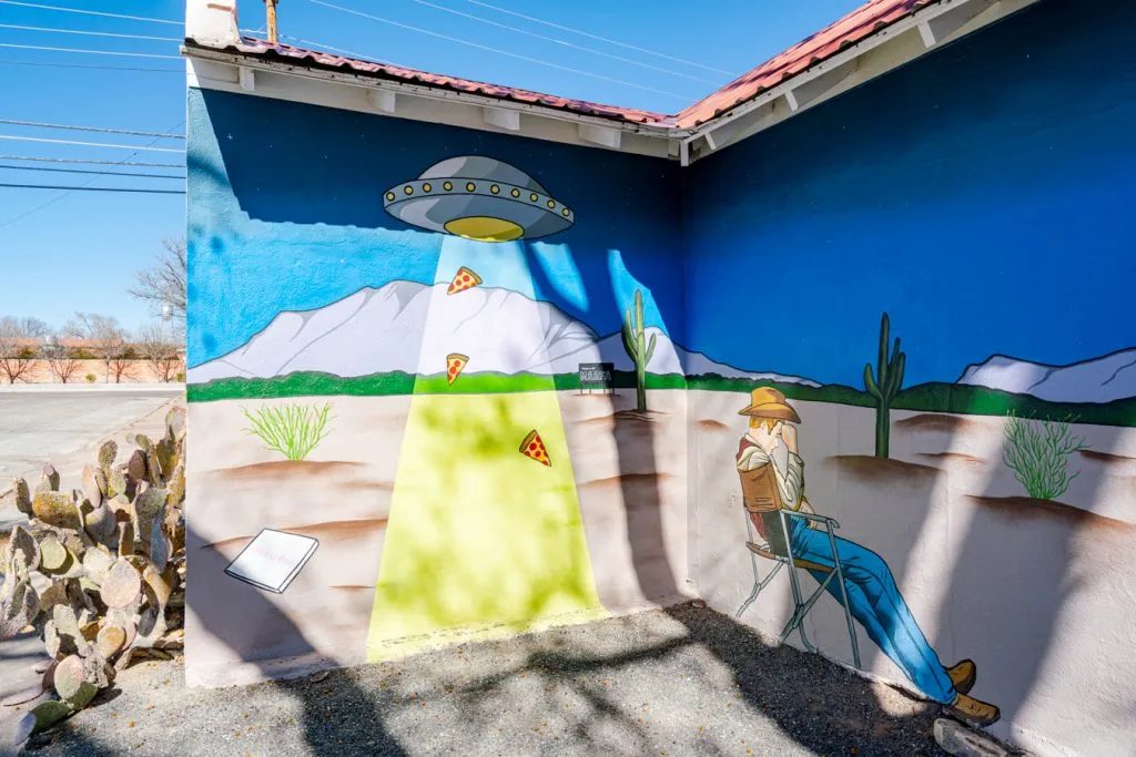 mural showing pizza slices being taken by a ufo in marfa texas