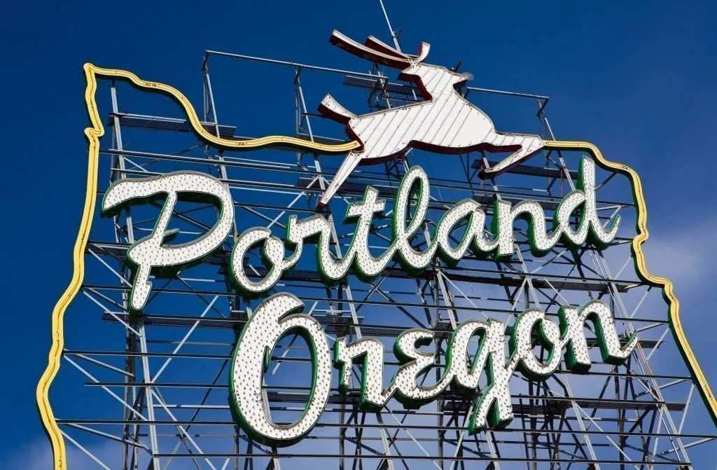 Photo of steal sign stating "portland oregon" in front of a blue sky, a must-see during 3 days in portland or