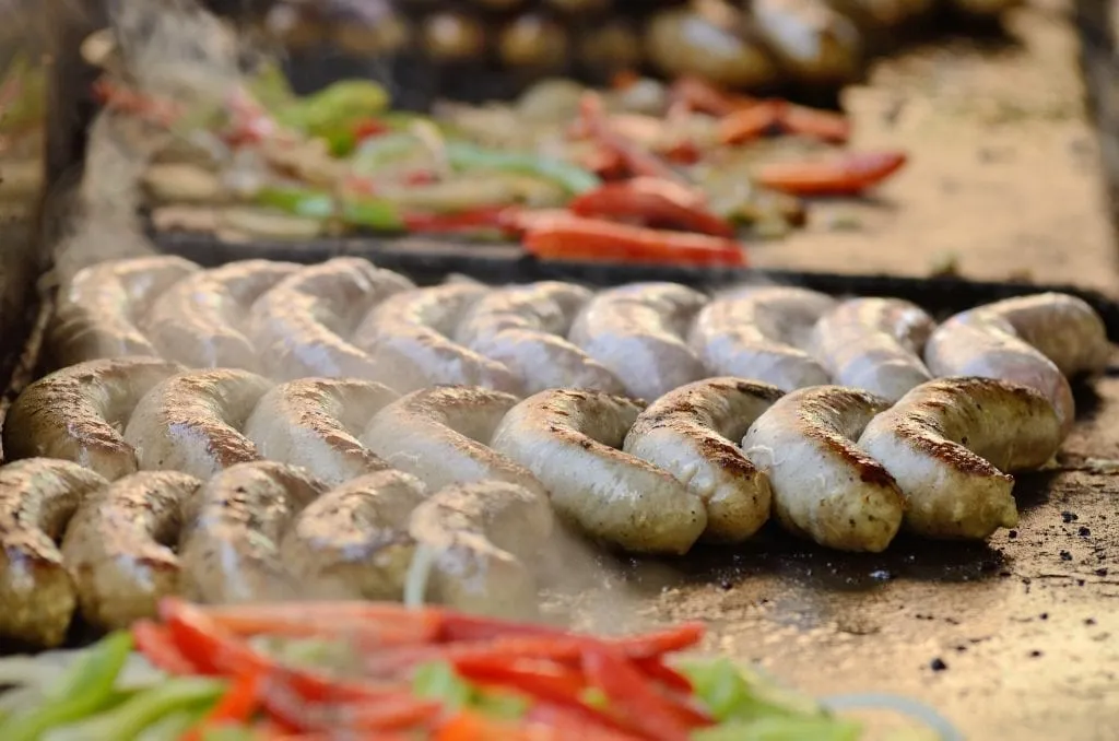 sausages and peppers sizzling on a grill at a portland oregon food truck